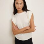 Cream sleeveless top styled with black pants for a chic outfit