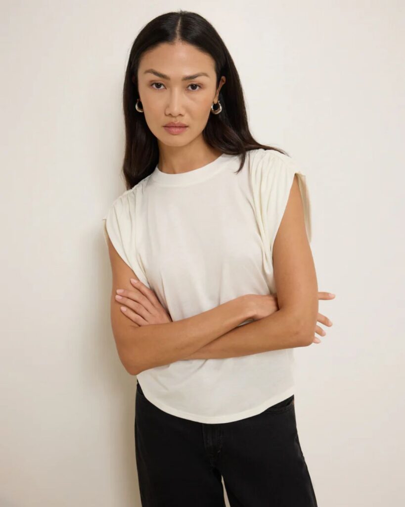 Cream sleeveless top styled with black pants for a chic outfit