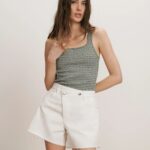 Striped tank top styled with high-waisted white shorts