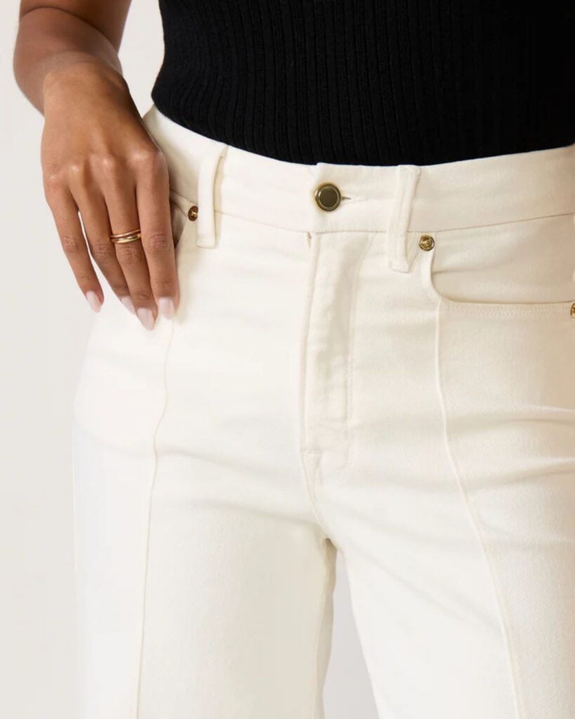 Close-up of high-rise white jeans with front pockets