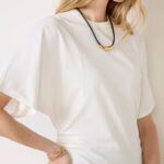 White draped short-sleeve top styled with a simple necklace