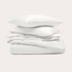 Folded white bedding and pillows