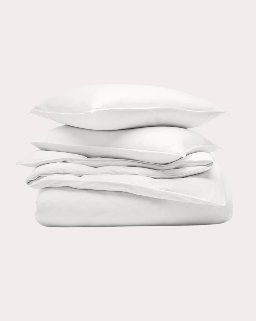 Folded white bedding and pillows